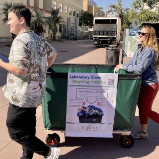 Two People Rolling Cart of Glove Pick Up