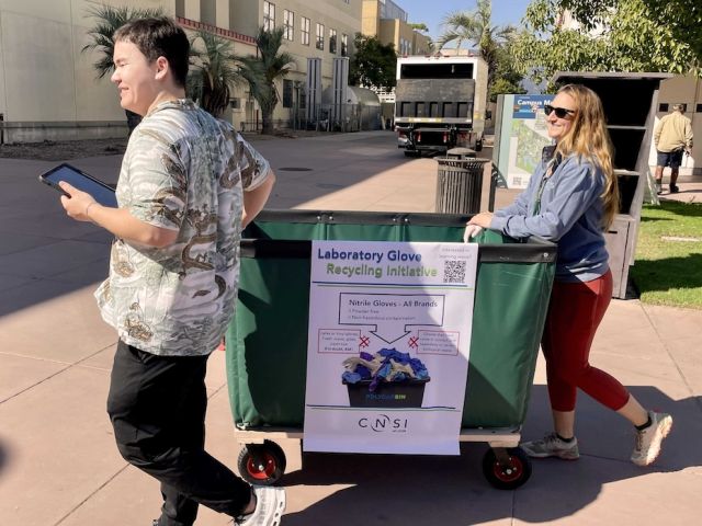 Two People Rolling Cart of Glove Pick Up